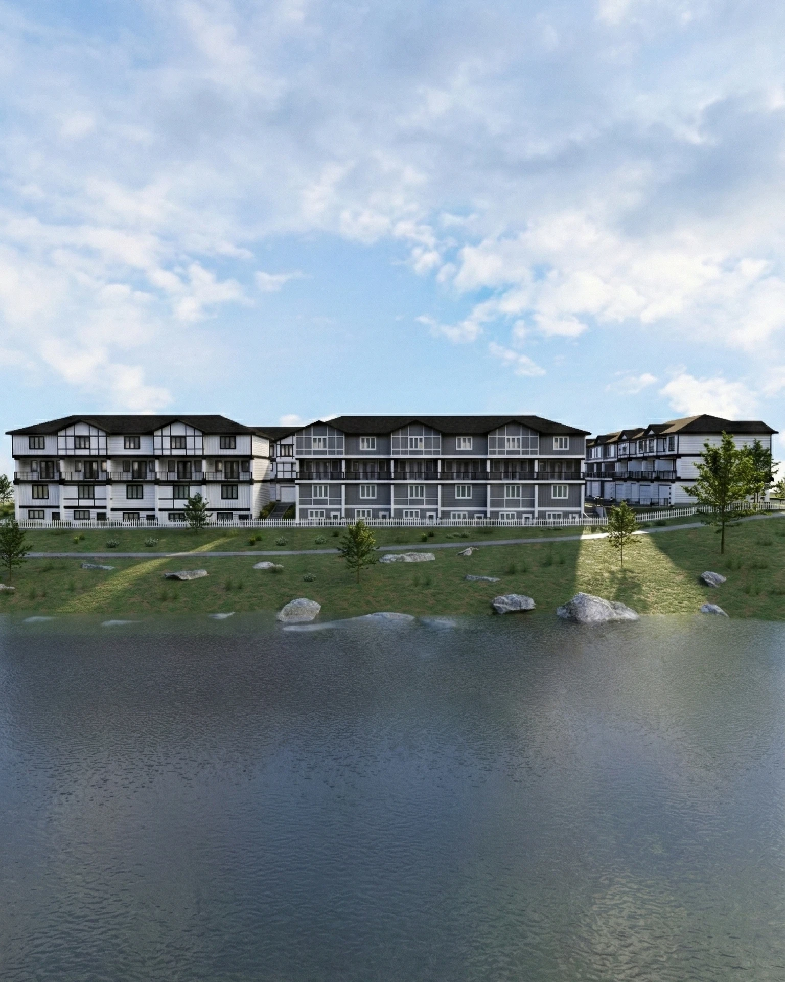 Low-rise multifamily buildings arranged near a landscaped water edge with contextual site planning